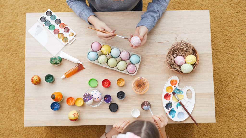 Imagen de dos niños pintando huevos de pascua
